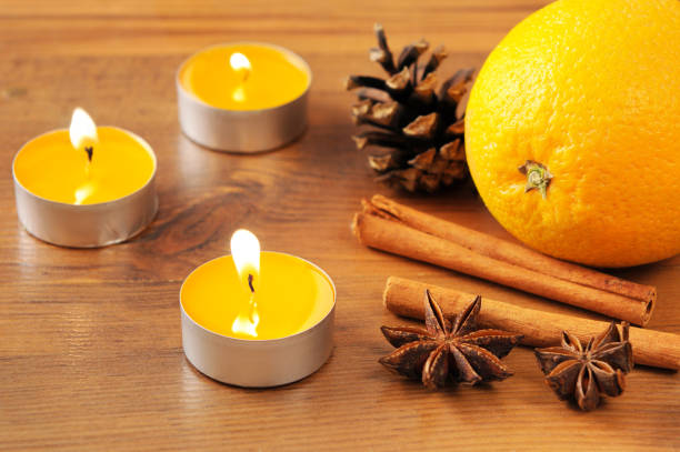 istock orange tealights buring and christmas decoration like pine cone on a bowl 1072435116