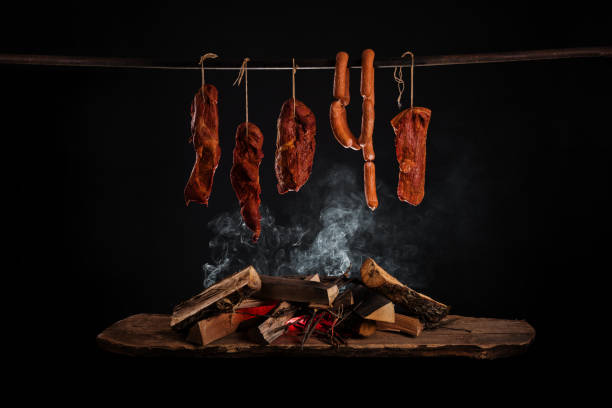 Smoked meat products Smoked ham, bacon, pork neck and sausages in a smokehouse. smoked food stock pictures, royalty-free photos & images
