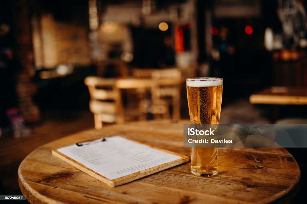 Pint of beer at the english pub. A pint of beer on a wood table at the Irish Pub. Alcohol - Drink Stock Photo
