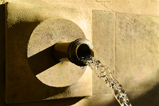 A traditional Provencal village fountain at sunset on summertime.