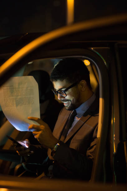 istock Manager reading positive report in car late at night 1072462464