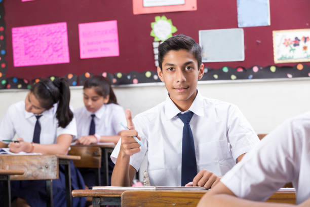 istock Male student in classroom thumb up  - Stock image 1072469756