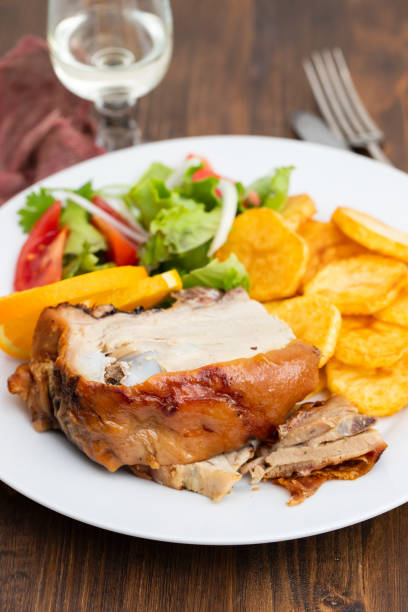 istock roasted piglet with potato chips and orange on white plate 1072471112