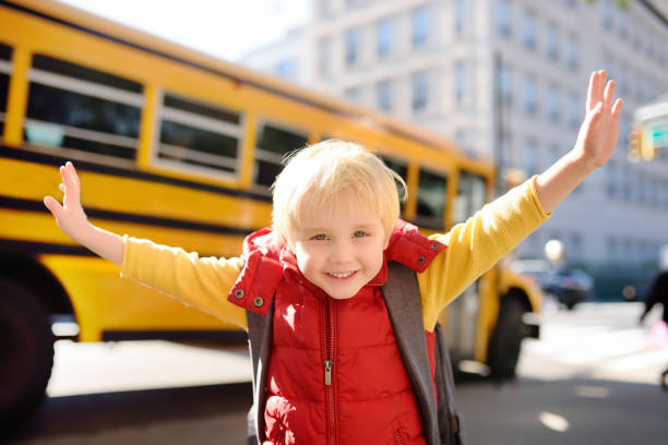 pupila con mochila con autobús amarillo sobre fondo - little boys preschooler back to school backpack fotografías e imágenes de stock