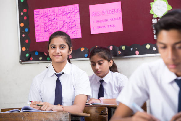 istock Females student in classroom writing in notebook - Stock image 1072472508