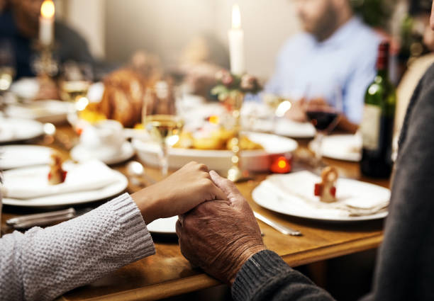 Bless this food we are about to eat Cropped shot of unrecognizable people holding hands in prayer before having a Christmas lunch together saying grace stock pictures, royalty-free photos & images