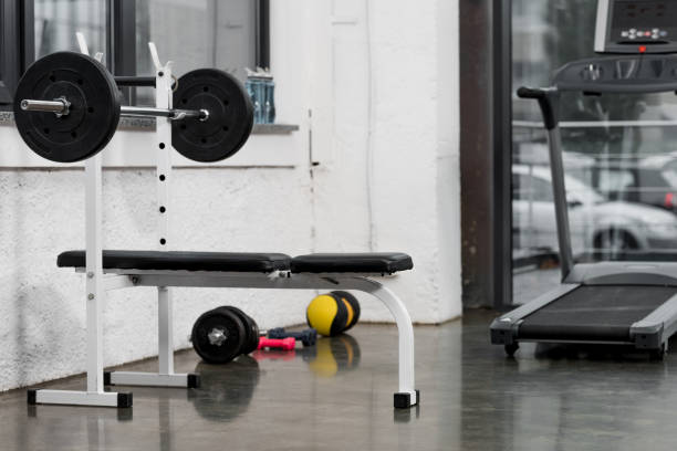 istock treadmill, barbell and weights in modern gym 1072477182
