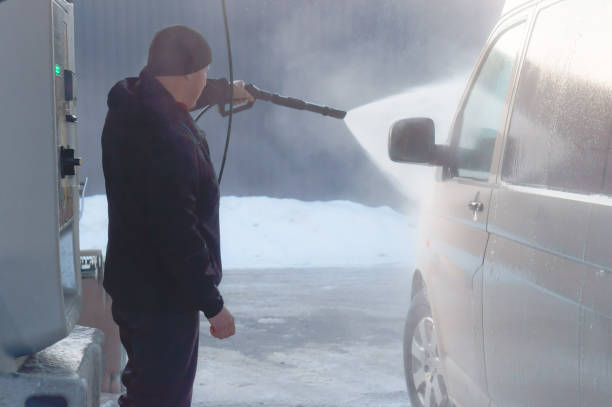 washing the car on a contactless sink, a man washes his white van stock photo