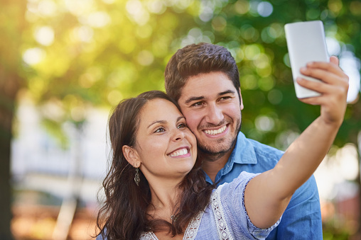Shot of a happy young couple taking a selfie together in the park