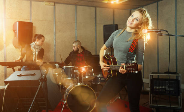 istock Cheery guitar player and singer with band 1072487448