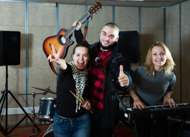 istock expressive group of rock musicians posing with instruments 1072487462