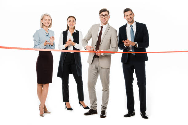 istock professional leader cutting red ribbon on opening ceremony while colleagues applauding, isolated on white 1072490524