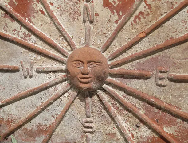 a compass rose or compass card with the sun in the centre on a ceramic plantpot