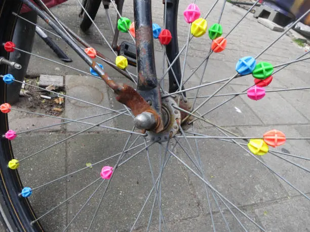 a wheel of an old bike decorated with colored beads