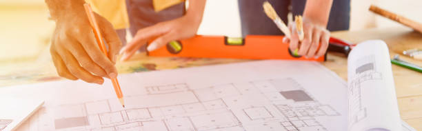 istock cropped image of couple making notes in blueprint for renovation 1072495764