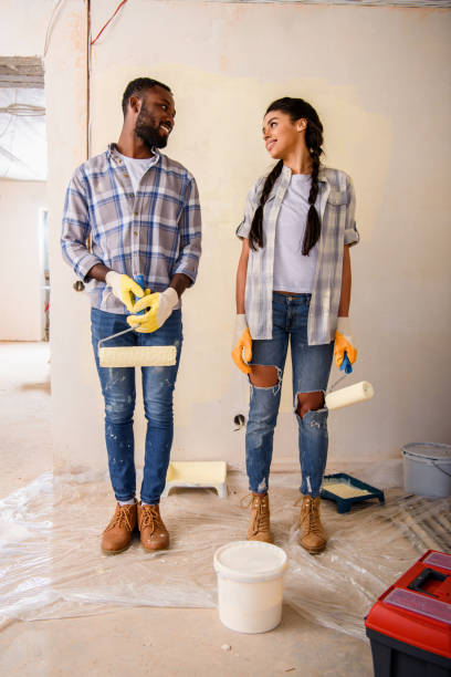 istock young couple with rolling brushes looking at each other while making renovation of home 1072496234