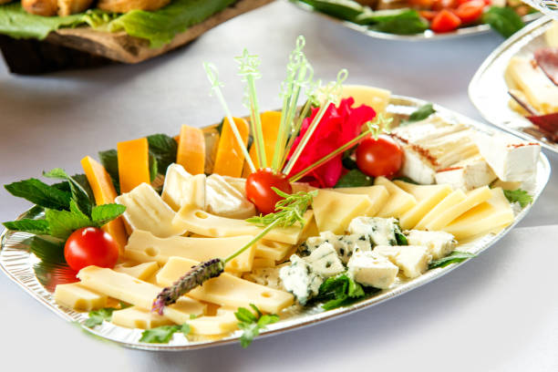 istock Different types delicacies of meat and cheese arranged in a plate over light background - selective focus 1072497480