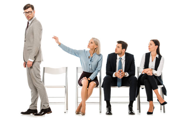 istock fired businessman going away from coworkers sitting on chairs isolated on white 1072497658