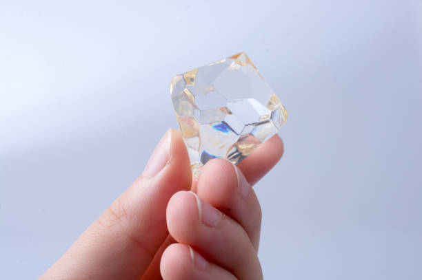 istock Hand holding a transparent diamond on white background 1072502288