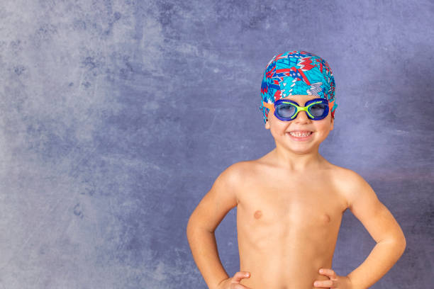 Little kid with a swimming cap and pool glasses
