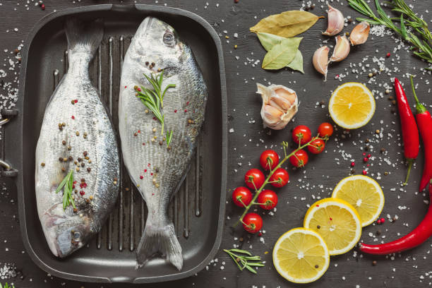 istock elevated view of uncooked fish near ingredients on black table 1072504004
