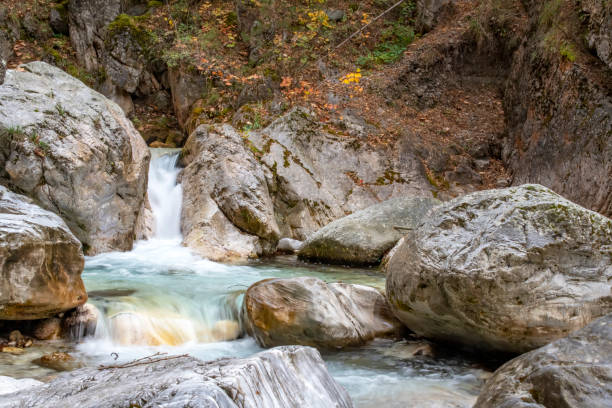 istock Waterfall and river between stone boulders in a mountain autumn forest 1072504198