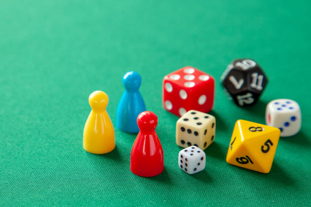 istock Colored game figures chips for board games. Collection of dice cubes on green table 1072504662