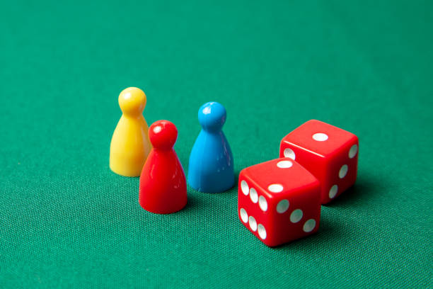 istock Colored game figures chips for board games. Collection of dice cubes on green table 1072504718