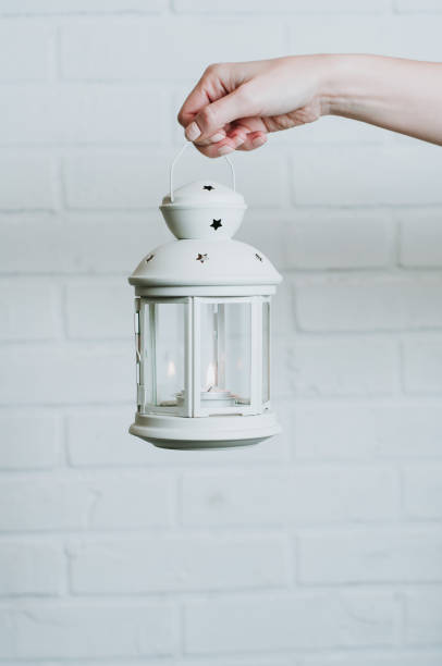 istock Woman holding a Christmas lantern on a white wall background 1072505708