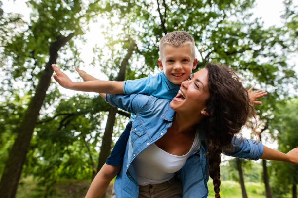 istock Smiling mother giving her son piggyback ride 1072506180
