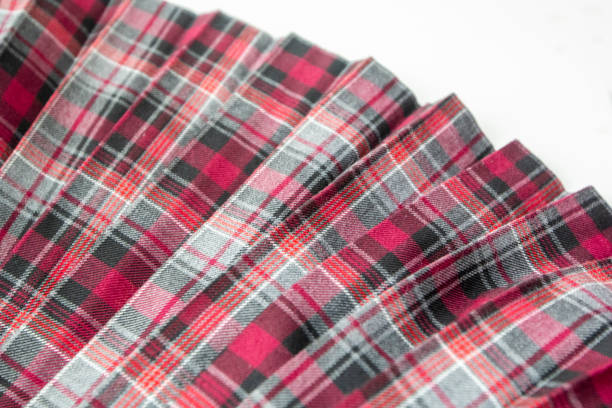 detail of new fashion plaid pleated skirt: red, maroon, gray tartan school uniform fabric cotton/woolen material, blurred focus. - circular skirt fotos imagens e fotografias de stock