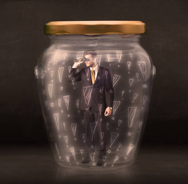 istock Business man trapped in jar with exclamation marks concept 1072515726