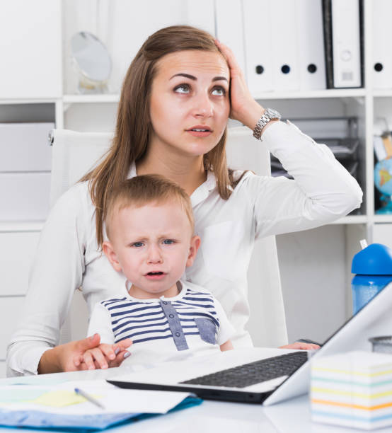 istock Perplexed female 22-27 years old is having issue while working behind laptop with child 1072518500