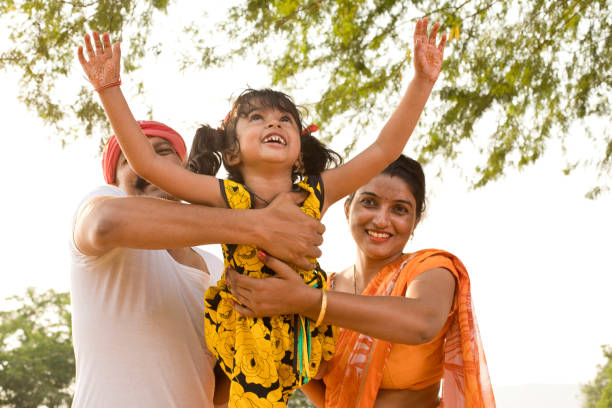 Cheerful parents lifting daughter and helping her fly