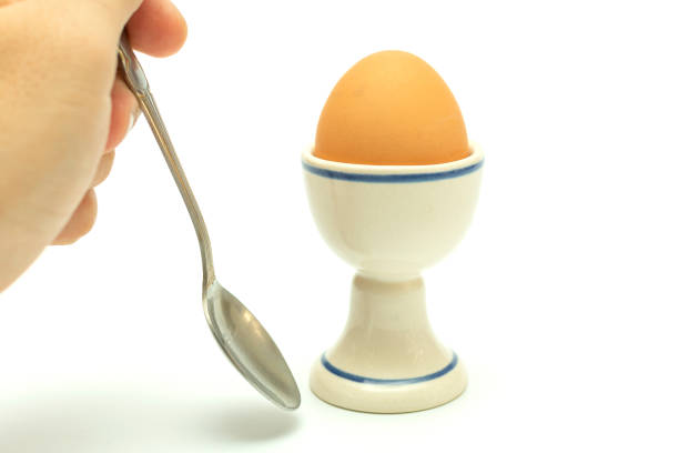 istock boiled chicken egg in a ceramic stand and a hand with a teaspoon nearby 1072522540