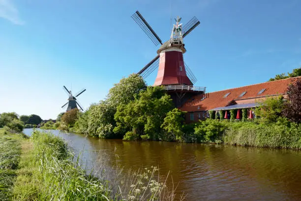 Two windmills in Greetsiel under blue sky. Krummhörn, Aurich - district, East Frisia, Lower Saxony, Germany, Europe.