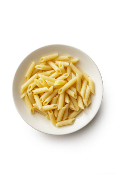 Plate of hot penne  with ingredients in the background.