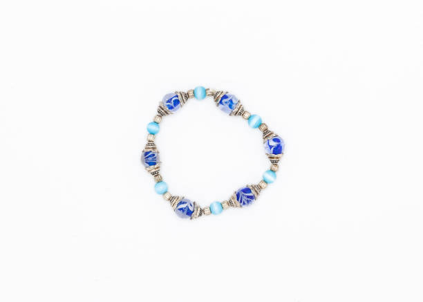 istock blue colored and variously sized beads bracelet on white background 1072525622