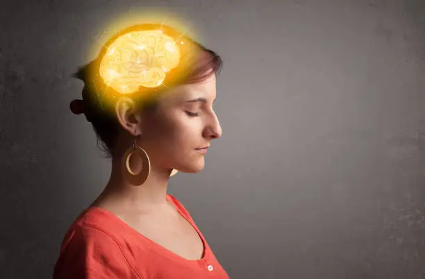 Photo of Young girl thinking with glowing brain illustration