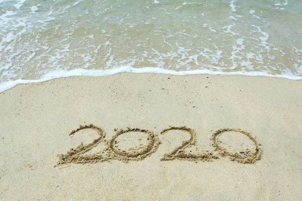 istock 2020 number written on sand beach with waves 1072528818