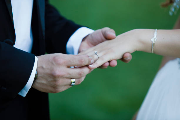 istock groom is giving ring to bride before wedding 1072531726