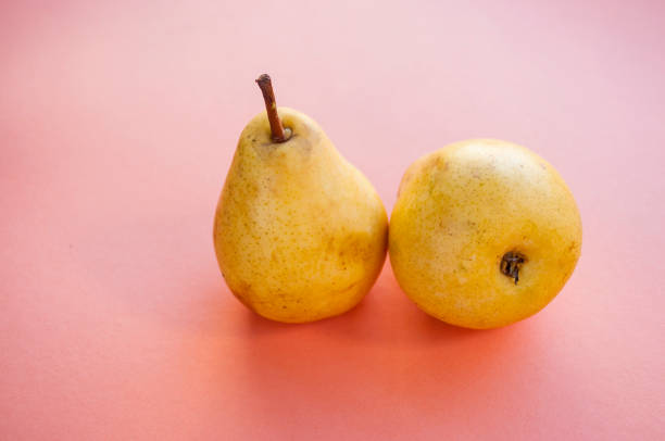istock Two yellow ripe pears on a pink background. 1072532558