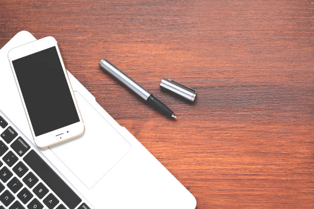 istock Laptop, pen and phone with empty screen 1072536600