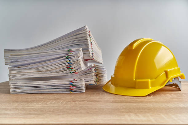 istock Pile overload document of report with yellow engineer hat 1072539032