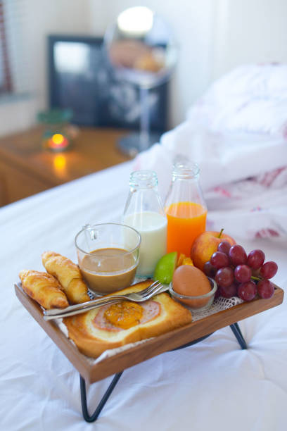istock Breakfast on bed with coffee, croissants Window light 1072540148
