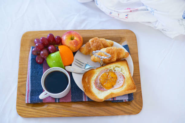 istock Breakfast on bed with coffee, croissants Window light 1072540212