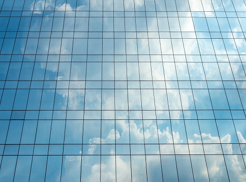 This is a background photograph of the sky reflecting clouds on the exterior of a glass office building in downtown Orlando, Florida, USA.