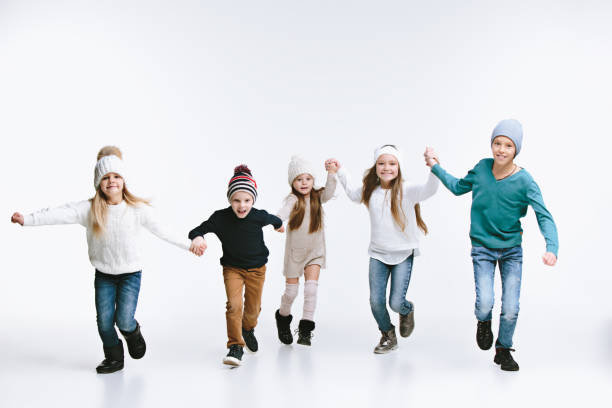 Group of kids in bright winter clothes, isolated on white Group of kids in bright winter clothes, isolated on white studio. Fashion, childhood, happy emotions concept kids winter fashion stock pictures, royalty-free photos & images