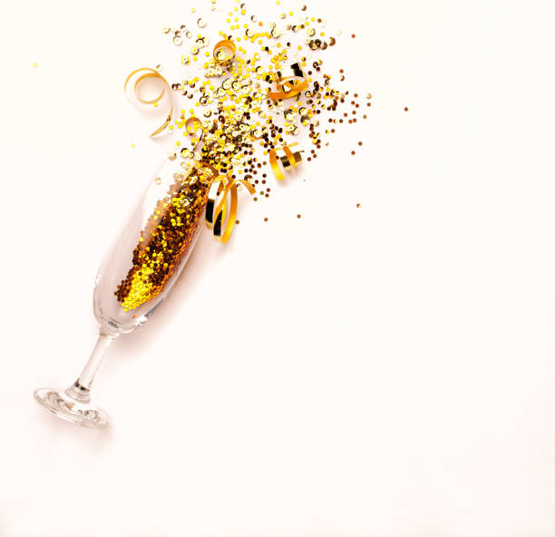 champagne glass with golden glitter on pink background. flatlay. copy space. new year concept - copy space single object confetti nobody imagens e fotografias de stock