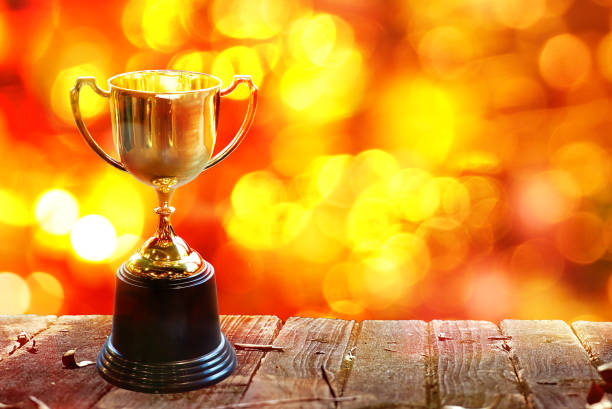 istock Chamption trophy on wood table with abstract bokeh background, have space for idea. 1072556388